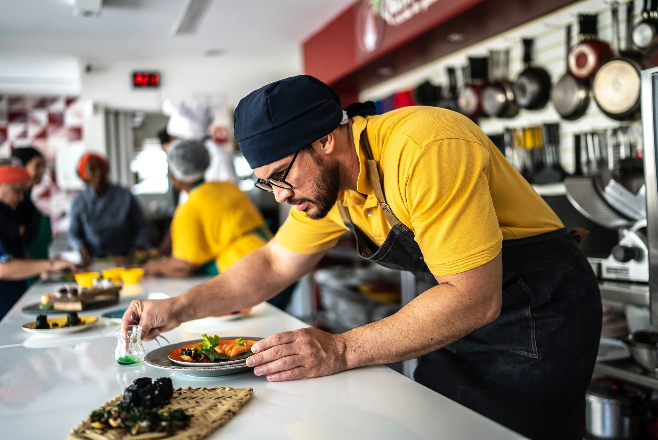 Chef plating a dish in a restaurant kitchen