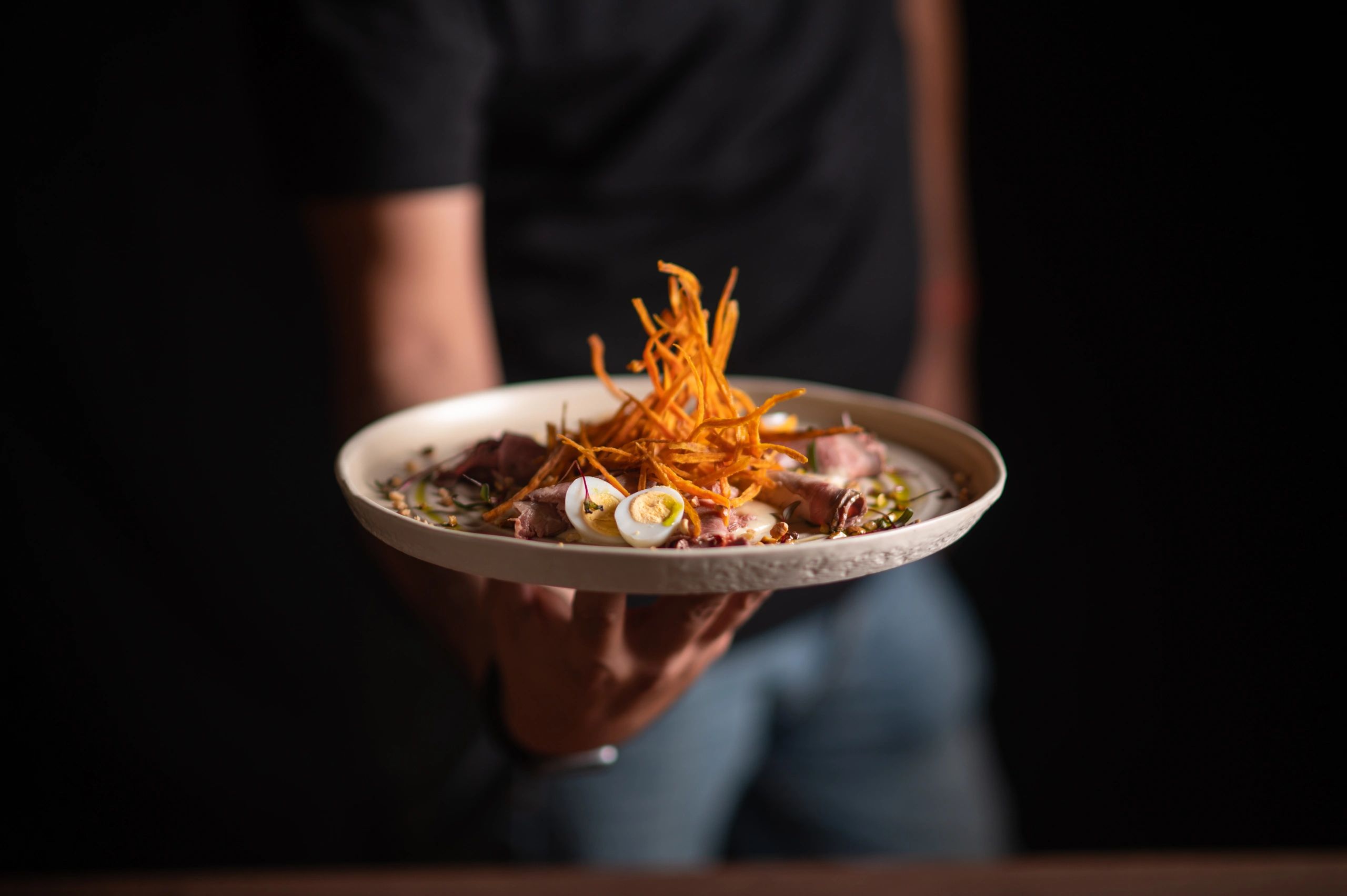 Chef presenting a fine dining dish for a photoshoot