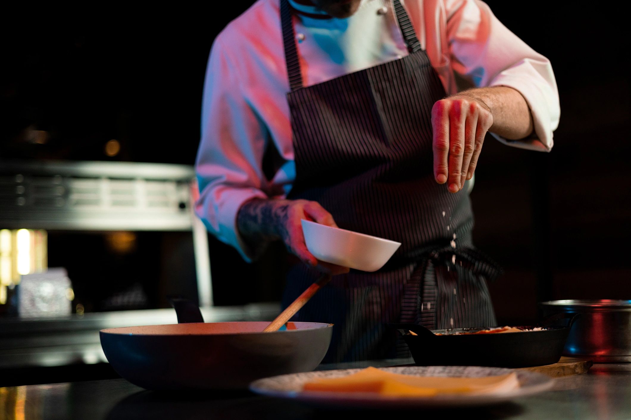 Chef seasoning a dish