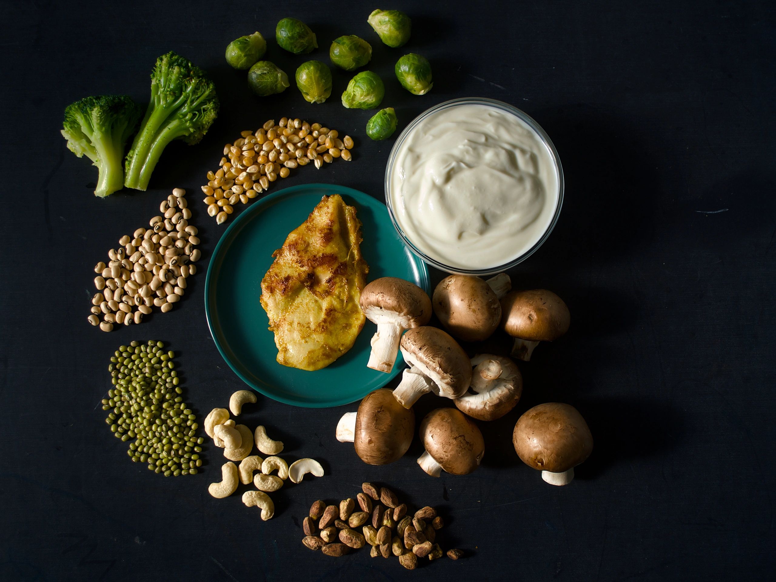 High-protein foods arranged on a black background for a bold product-style composition