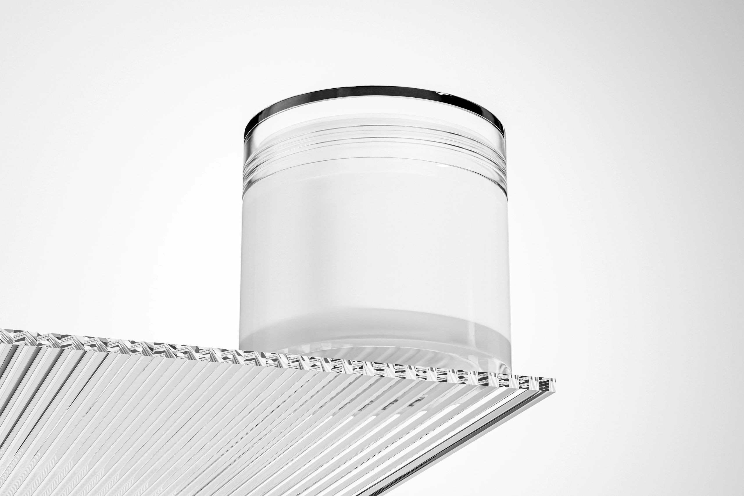 Clear glass cosmetic jar packaging mockup in a minimal studio setup