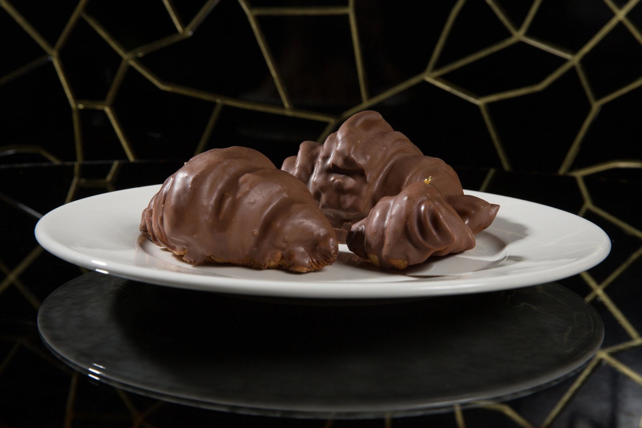 Chocolate croissants plated on a white ceramic dish