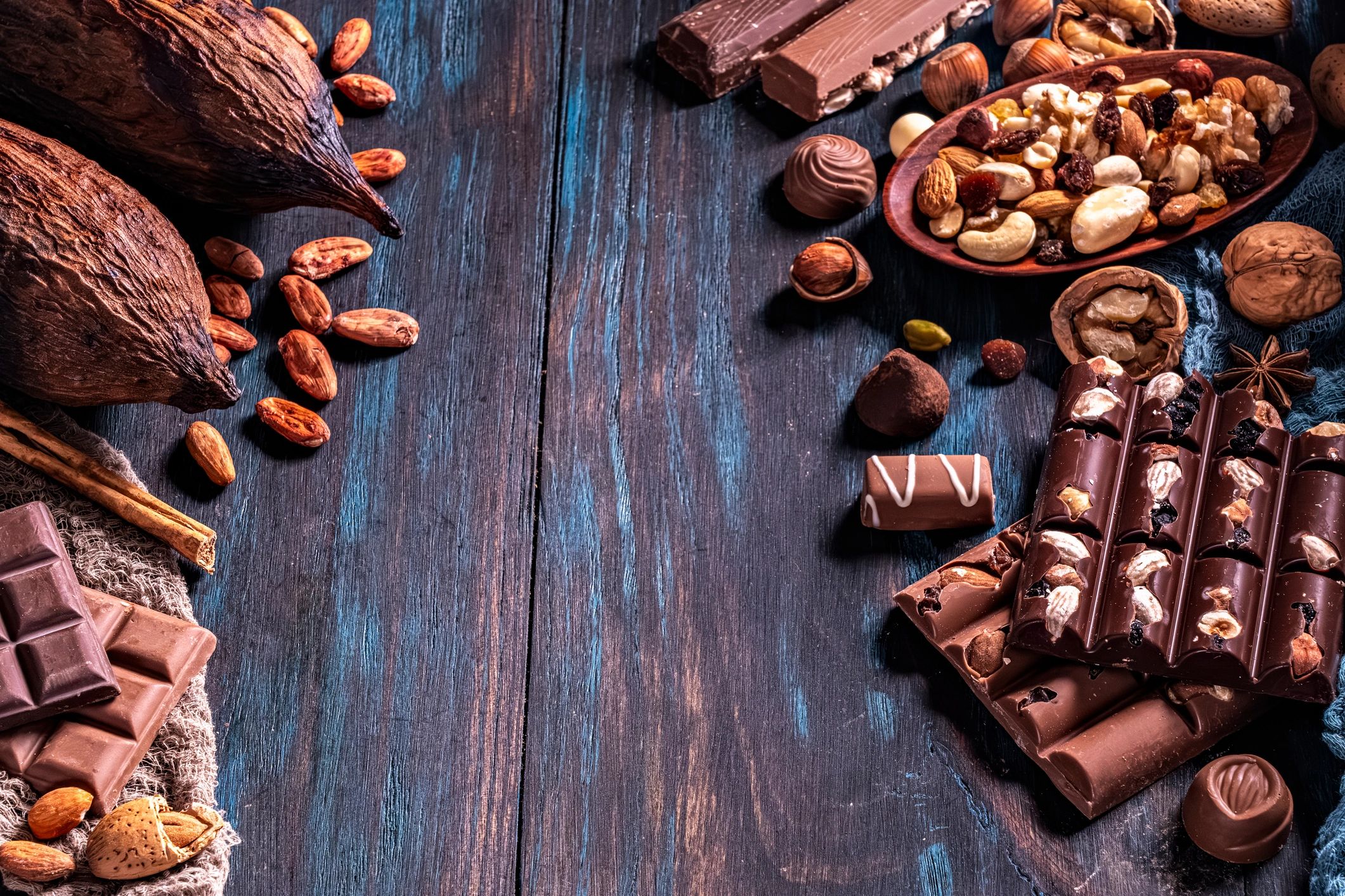 Assortment of chocolate, nuts, and dried fruit on a rustic table